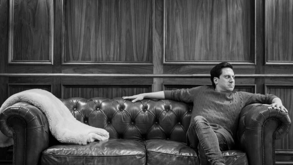 a man sitting on a couch with a cat on it